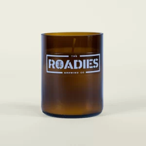Brown glass candle with the words The Roadies on it
